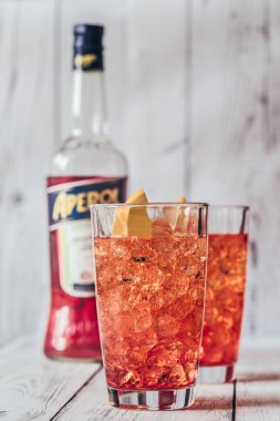 Sumy, Ukrayna - 29 Ağustos 2018: Cam, Aperol Spritz kokteyl Aperol şişe beyaz ahşap zemin üzerinde. Aperol ünlü İtalyan Aperatif olduğunu.