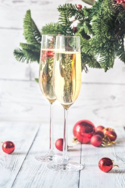 İki bardak şampanya ile Noel ağacı dalı