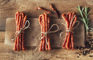 Kabanosy sausages with spices on the wooden background clipart