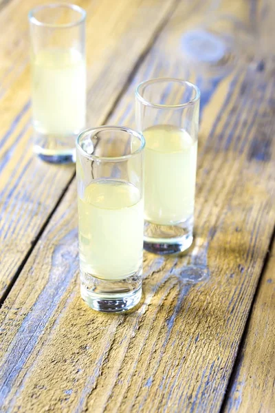 Trzy Szklanki Limoncello Drewnianym Tle — Zdjęcie stockowe