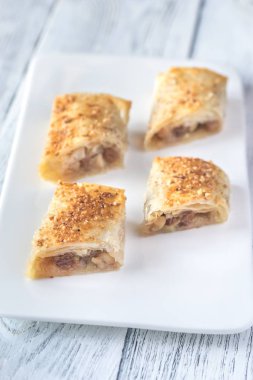 Elmalı turta dilimleri beyaz tabakta.