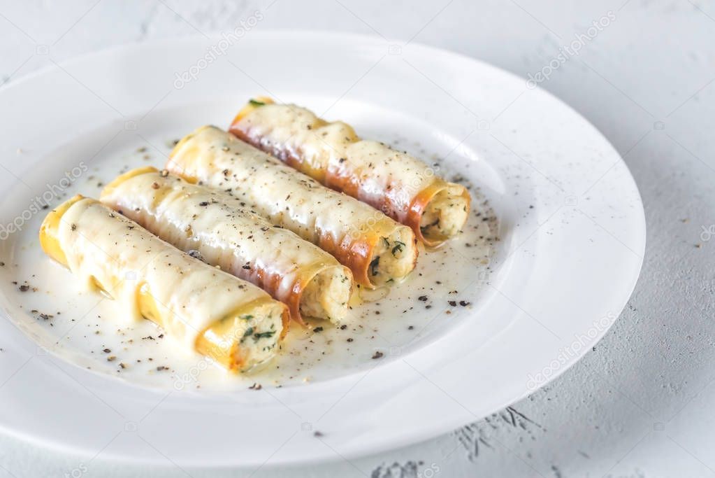 Cannelloni stuffed with ricotta on the white plate