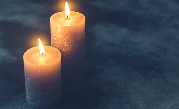 Dos Velas Encendidas Sobre Fondo Azul Marino —  Fotos de Stock