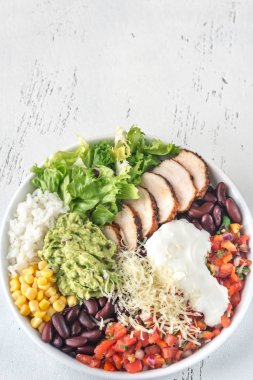 Tavuk, salsa, mısır, pirinç, fasulye ve guacamole soslu burrito kasesi.