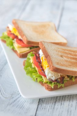 İki parça kızarmış yumurta ve pastırmalı ekmek.