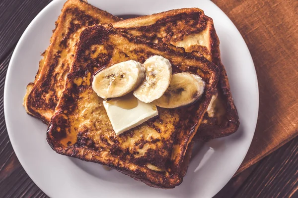 French toast with butter, sliced banana and maple syrup