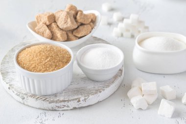 Ahşap arka planda farklı şekillerde şeker var.