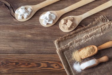 Ahşap arka planda farklı şekillerde şeker var.