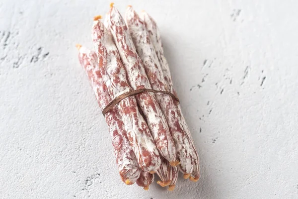 Snack fuet worstjes op de houten achtergrond — Stockfoto