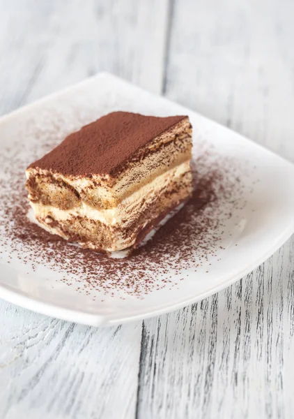 Tiramisu beyaz tabakta bölümünü — Stok fotoğraf