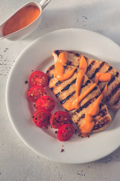 Жареная куриная грудка с соусом и помидорами черри — стоковое фото