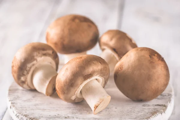 Champignon mushrooms on the wooden board — Stock Photo, Image