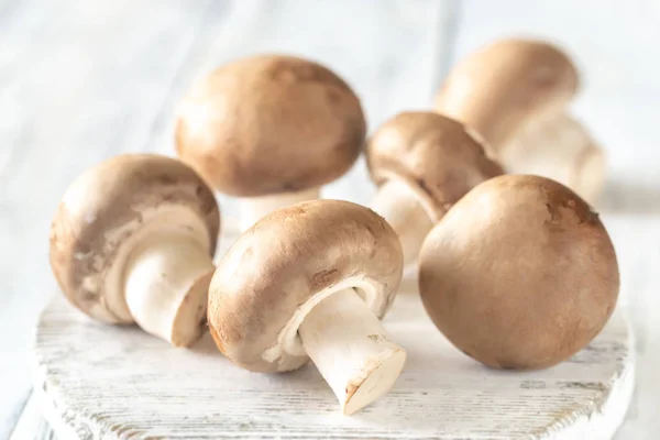 Champignon mushrooms on the wooden board — Stock Photo, Image