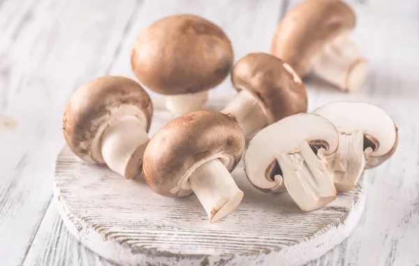 Champignon mushrooms on the wooden board — Stock Photo, Image