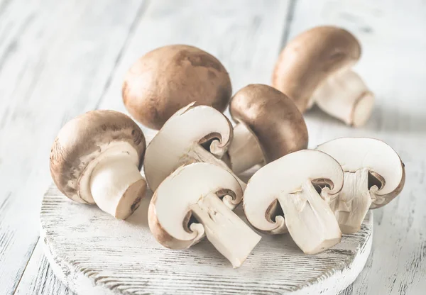 Champignon mushrooms on the wooden board — Stock Photo, Image