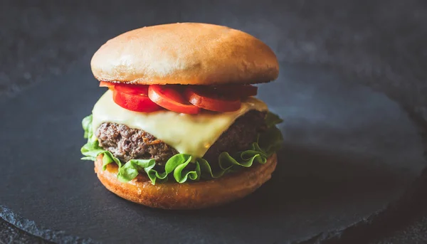 Hamburger auf der schwarzen Steintafel — Stockfoto