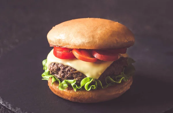 Hamburger auf der schwarzen Steintafel — Stockfoto