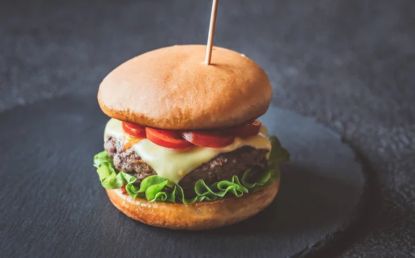 Hamburger auf der schwarzen Steintafel — Stockfoto