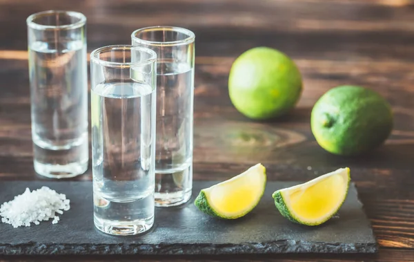 Glas tequila med lime kilar — Stockfoto