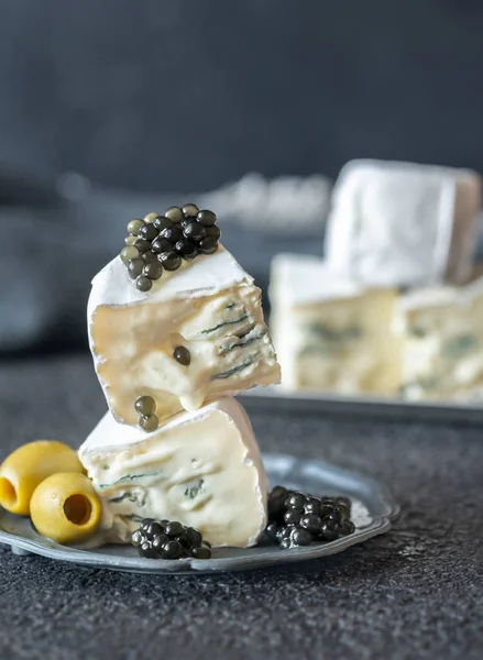 Белый и синий сыр с черной икрой крупным планом — стоковое фото