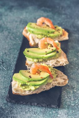 Avokado ve karidesli sandviç.