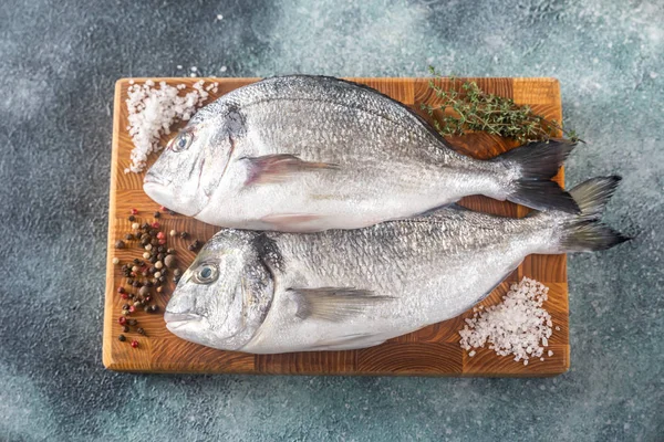 Dorada fresca na tábua de madeira — Fotografia de Stock