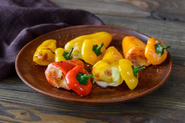 Beyaz tabakta mozzarella ile doldurulmuş mini tatlı biberler.