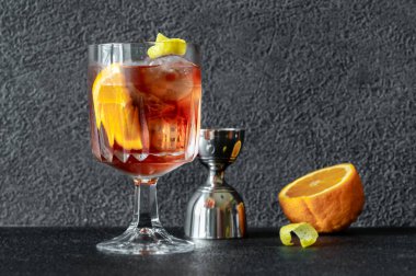Bir bardak portakal dilimi ve limon aromalı Americano kokteyli.