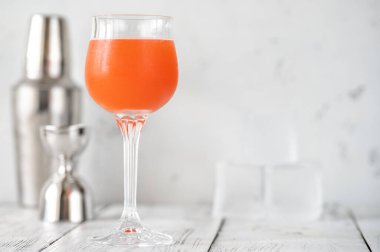 Beyaz arka planda bir bardak maymun bezi kokteyli.