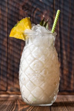 Bir bardak ananas parçasıyla süslenmiş Pina Colada kokteyli.
