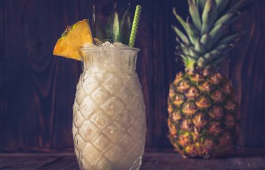 Bir bardak ananas parçasıyla süslenmiş Pina Colada kokteyli.