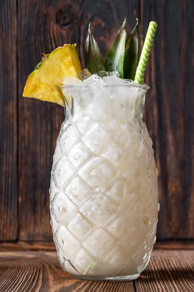 Bir bardak ananas parçasıyla süslenmiş Pina Colada kokteyli.