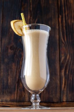 Bir bardak muzlu kokteyl ahşap sırtüstü.