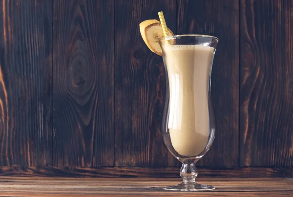 Bir bardak muzlu kokteyl ahşap sırtüstü.