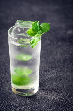 Siyah arka planda bir bardak mojito kokteyli.