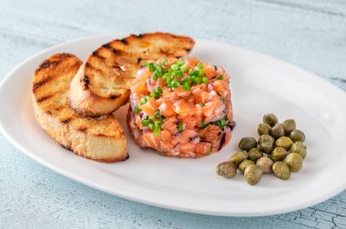 Kızarmış ciabatta ve kapari ile somon tartar.