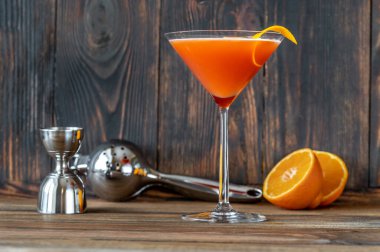 Bir bardak kan ve portakal kabuğuyla süslenmiş martini bardağında kum kokteyli.