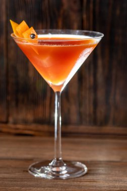 Glass of Blood And Sand Cocktail in martini glass garnished with orange peel clipart