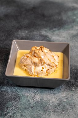 Vanilyalı kremanın üzerinde yüzen kremadan yapılmış yüzen ada tatlısı.