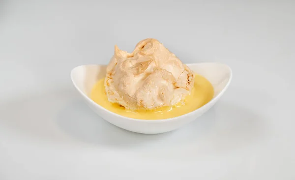 Floating island dessert made of meringue floating on vanilla custard