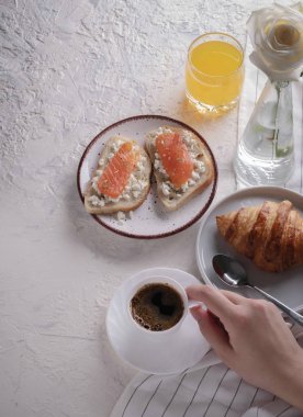 Continental kahvaltı (üstten görünüm yukarıda, düz yatıyordu) ele geçirdi. Kahve, portakal suyu, kruvasan, sandviç ve çiçekler. Kopya alanı.