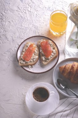 Continental kahvaltı (üstten görünüm yukarıda, düz yatıyordu) ele geçirdi. Kahve, portakal suyu, kruvasan, sandviç ve çiçekler. Kopya alanı.