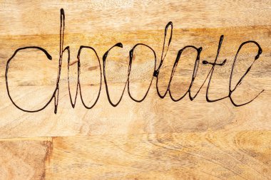 Kitabe çikolata ile eritilmiş çikolata ahşap zemin, kopya alanı üzerine yazılmış