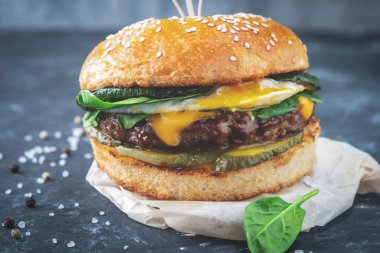 yakın çekim burger Dana pirzola ve ahşap bir masa, yakın çekim koyu arka plan üzerinde yumurta