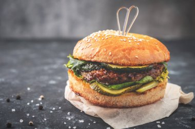 Burger bir tahta masa, yakın çekim, koyu arka plan üzerinde