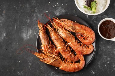 Pirinç şehriye, sos ve marul, koyu arka plan, kopya alanı ile Kızarmış ızgara karides