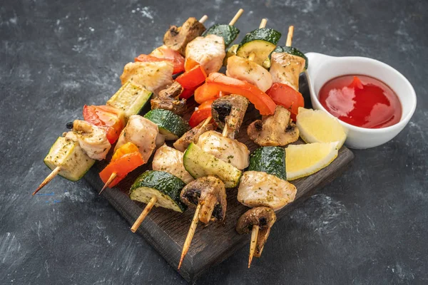 grilled vegetables and chicken fillet on a wooden board on a dark background, copy space,  close-up