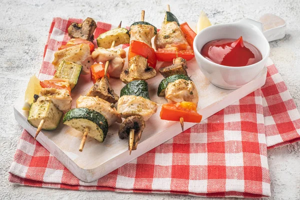 grilled vegetables and chicken fillet on a wooden board, close-up