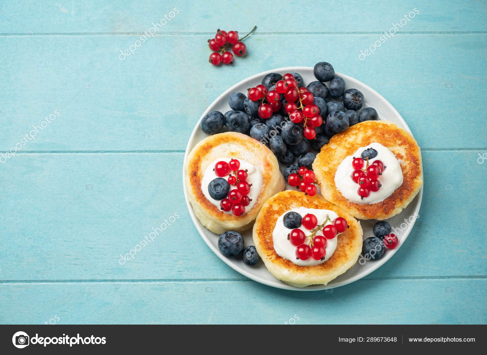 小屋奶酪煎饼与红色醋栗和蓝莓在蓝色背景——图库图片© yulya_taler #289673648, image size:1600x1167