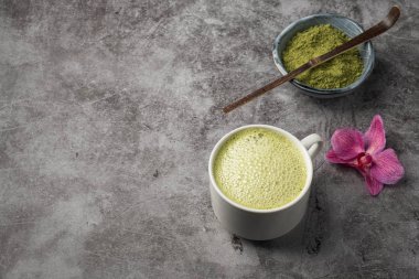 Latte matcha kahve. Japon matcha yeşil çay tozu, sağlıklı bir doğal ürün, antioksidan. Gri arka plan, yakın çekim, kopyalama alanı. 